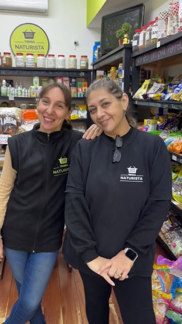 Dos integrantes del equipo con el uniforme de Tienda Naturista, adentro del local